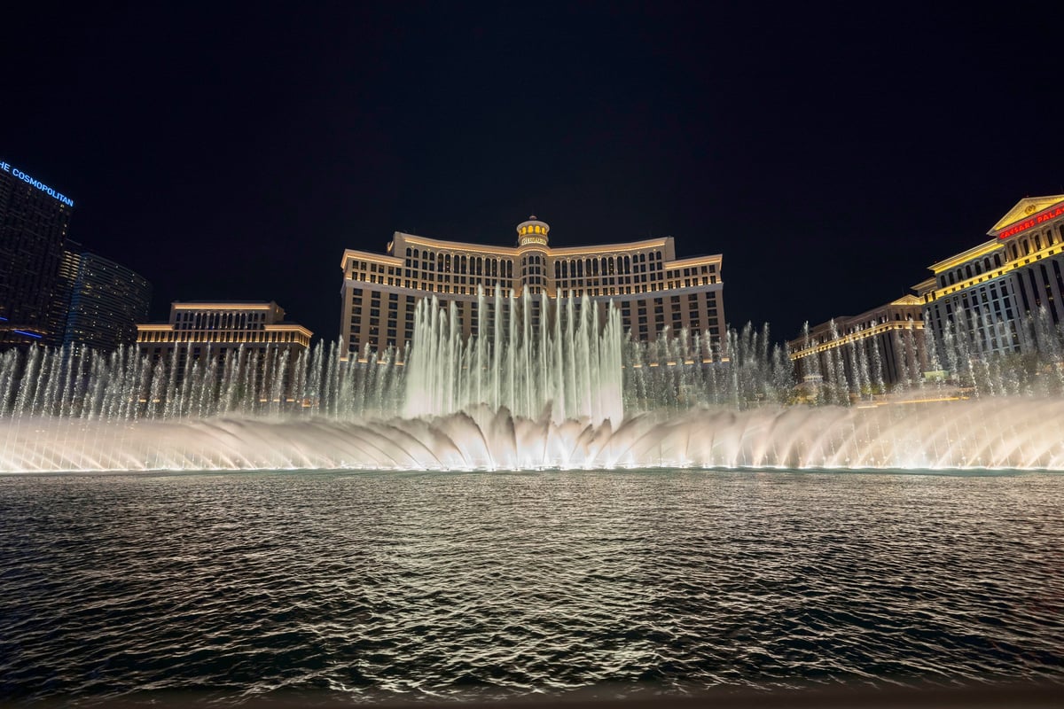 Night fountain show with illuminated water jets in front of the Bellagio hotel in Las Vegas