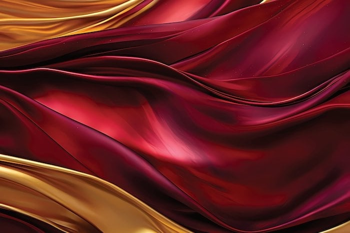 Abstract flowing waves of crimson red and gold fabric with smooth, curved lines creating a luxurious, elegant background design